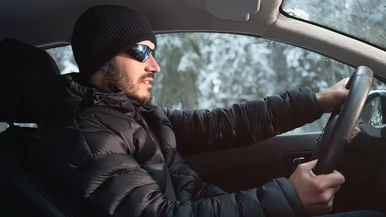 Hombre conduciendo con abrigo