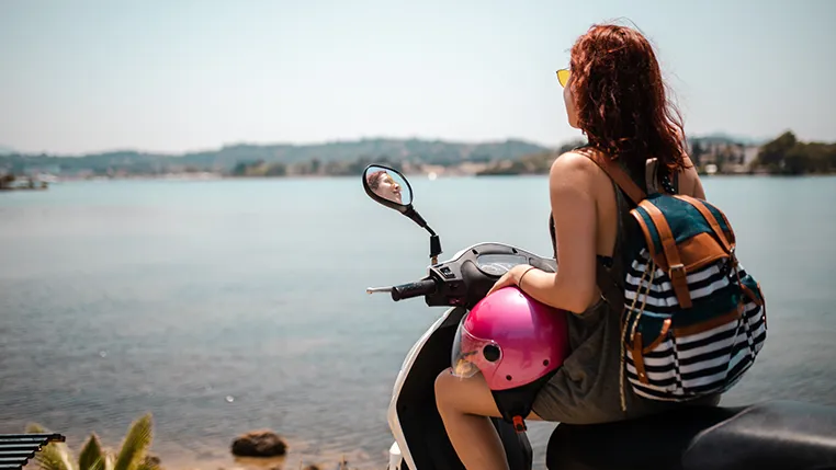 ¿Qué motos puedes conducir con el carnet B? Chica montada en moto viendo el mar