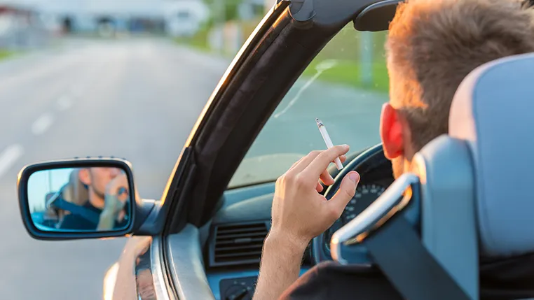 ¿Está prohibido fumar mientras se conduce? Normativa y sanciones en España Persona fumando en un descapotable
