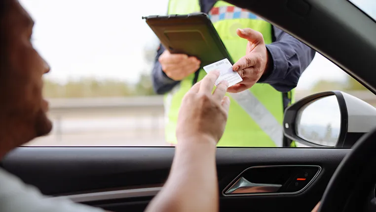 Conductor dándole el carnet de conducir a un policía