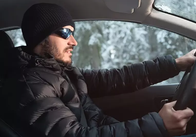 Hombre conduciendo con abrigo
