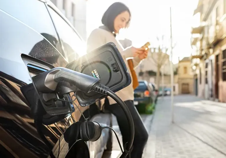 Persona cargando un coche eléctrico