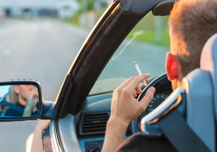 Persona fumando en un descapotable