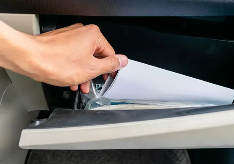Una mano cogiendo papeles de la guantera del coche
