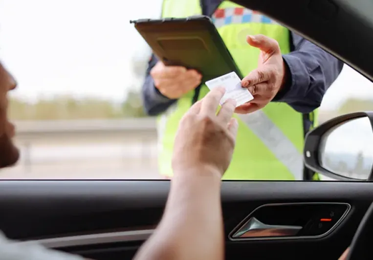 Conductor dándole el carnet de conducir a un policía