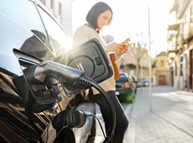 Persona cargando un coche eléctrico