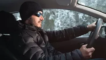 ¿Se puede conducir con el abrigo puesto? Hombre conduciendo con abrigo puesto