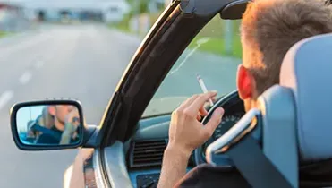 Persona fumando en un descapotable