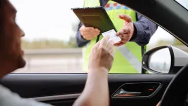 Conductor dándole el carnet de conducir a un policía