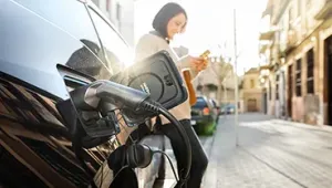 Persona cargando un coche eléctrico