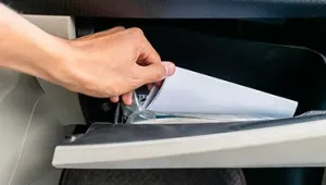 Mano cogiendo papeles de la guantera del coche