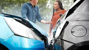 Dos personas fuera del coche mediando